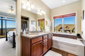 A bathroom with a double sink vanity, a bathtub, and a large window with a view of houses. - A Sweet Escape: 2br Condo in The Reserve on Sugar Mtn - Long Range Views! (Sugar Mountain)
