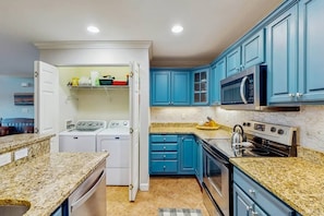 A kitchen with blue cabinets, a microwave, an oven, and a washing machine. - Sugar High at The Reserve II - Unobstructed Views (Banner Elk)