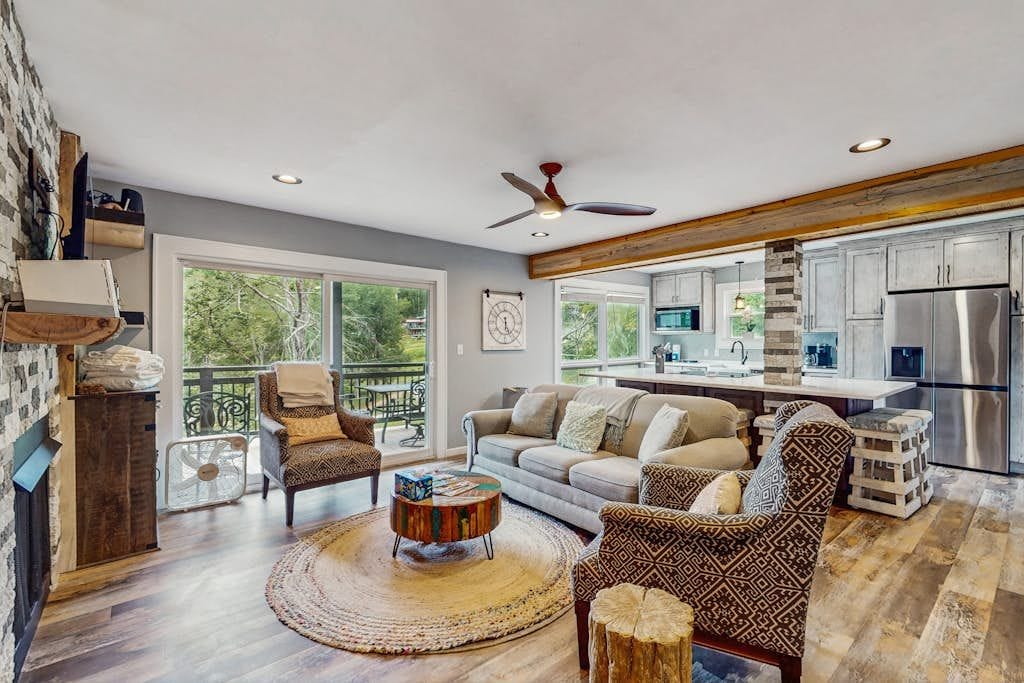 A spacious living area with a fireplace, a round coffee table, and a sofa.