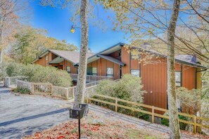 A modern building with a wooden exterior, a covered outdoor area, and a wooden fence. - Rotten Dog Getaway: Dog friendly slopeside 2br updated condo on Sugar Mtn! (Sugar Mountain)