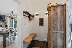 A modern interior with a dining area, a bench, a wall-mounted coat rack, and a wooden door. - Marla on the Mountain - Stunning Views, Sugar Mountain (Sugar Mountain)
