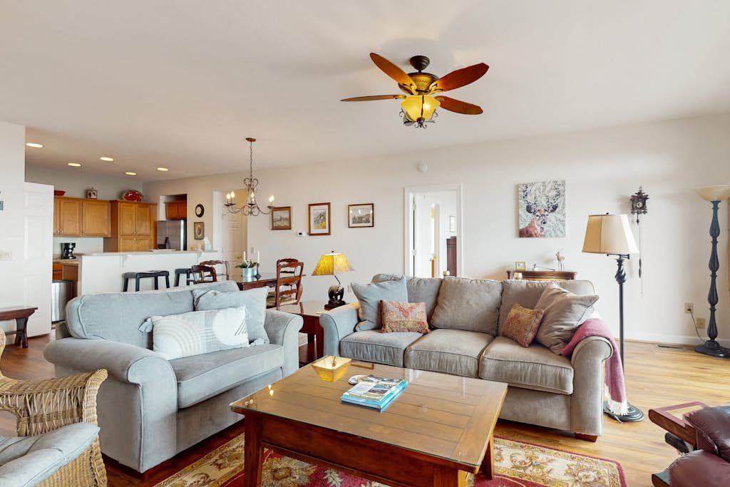 A living room with two sofas, a coffee table, and a ceiling fan.