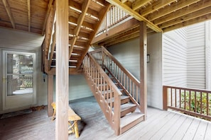 A wooden staircase leading to an upper level, a door with a window, and a bench on a wooden deck. - The Owl's Nest at The Reserve- Condo on Sugar Mountain with Amazing Views, Gas Fireplace! (Banner Elk)
