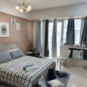 A bedroom with a bed, a desk, a chair, and a window with curtains. - XYZ’s Condo-One Palm Tree Villas, Newport: 6-Min Walk to NAIA T3 via Runway MNL (Unknown)