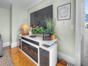 A reception desk with a signboard, a lamp, a plant, and a fireplace.