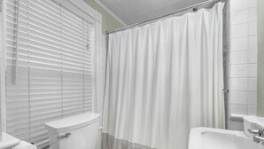 Een badkamer met toilet, wastafel en douchegordijn.