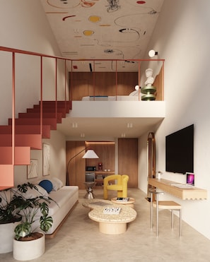 Un interior moderno con una escalera, un sofá, una mesa de centro y un televisor.