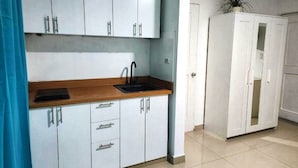 A kitchen with white cabinets, a wooden countertop, a sink, and a potted plant. - Gran sol caribe corales punta cana (Punta Cana)