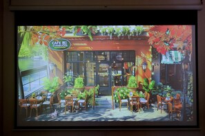 A cafe with outdoor seating, a sign reading 'CAFE STARBUCKS,' and a view of the street.
