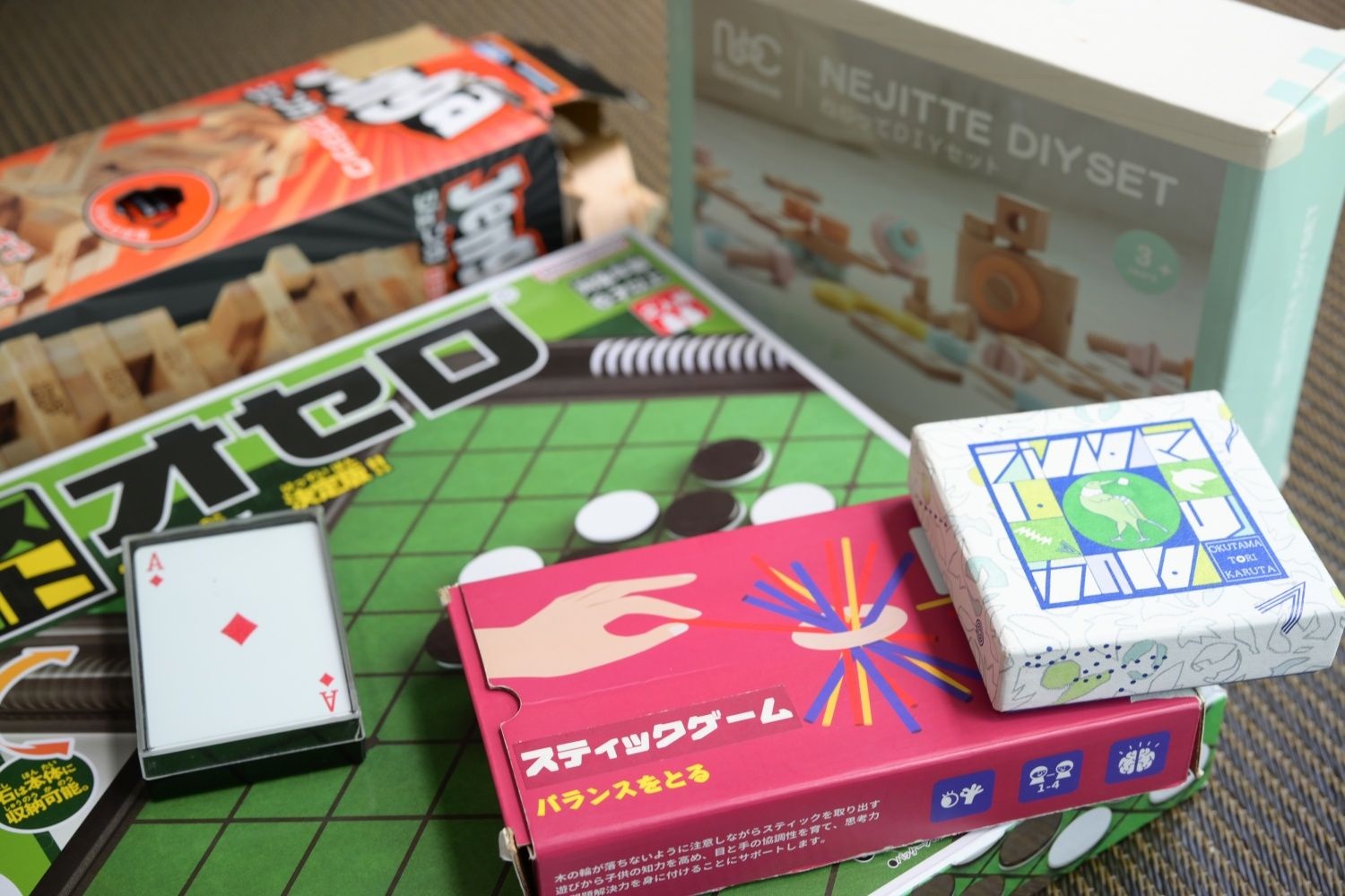 A tabletop with various game boxes, including a card game and a puzzle set.