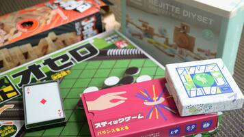 A tabletop with various game boxes, including a card game and a puzzle set.
