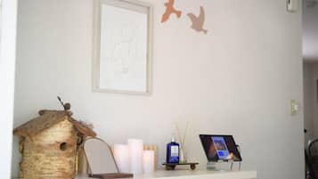 A reception desk with a framed sketch, candles, a birdhouse, and a tablet.