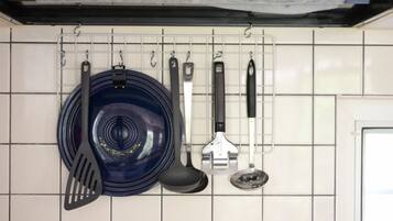 A kitchen with a hanging rack holding various utensils.