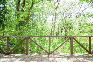 A wooden deck with a metal railing overlooking a dense forest. - Yatsugatake Angel AG1 (Hokuto)