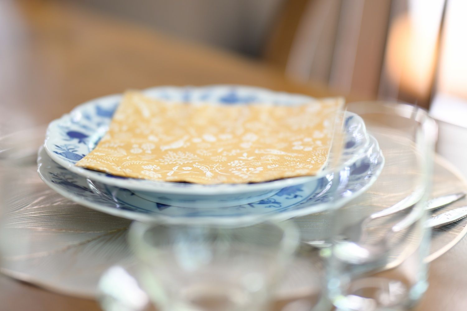 A crepe on a blue and white patterned plate on a glass table.