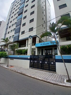 A multi-story building with a gated entrance, a sign reading 'R. Maceio,' and a tiled facade. - SHB 1 min praia - Família - Aconchegante (Praia Grande)