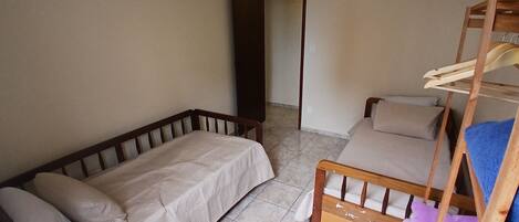 Una habitación pequeña y amoblada con un sofá, una litera y una escalera de madera.