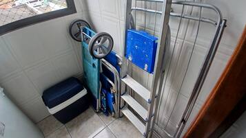 Casa de banho compacta com cabine de duche, um móvel de armazenamento azul e um pequeno banco.