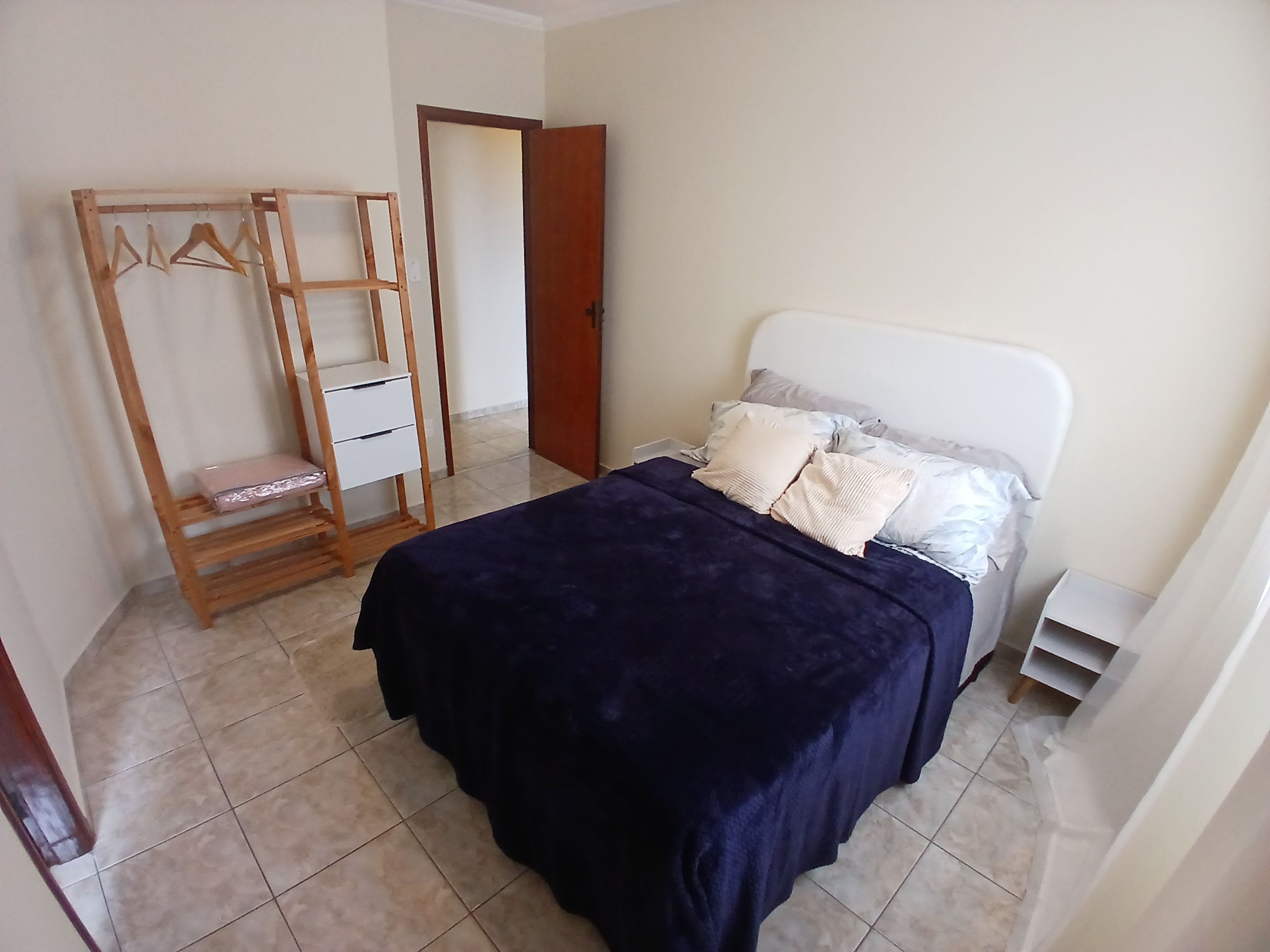 Un dormitorio con una cama, un armario de madera y una puerta.