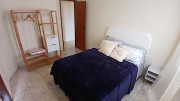 Un dormitorio con una cama, un armario de madera y una puerta.