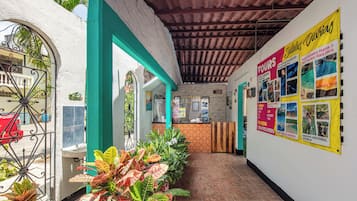 A reception area with a tiled floor, a reception desk, and a wall with a bulletin board advertising tours.