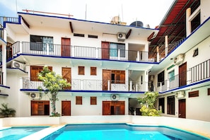 A multi-story building with a swimming pool in the foreground.