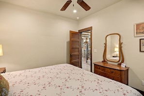 A bedroom with a bed, a dresser, a mirror, and a door leading to another room. - Fall Escape Special: 15% Discount Ends Nov 30! Must book by Oct 18 (Pagosa Springs)
