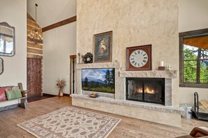 A living room with a fireplace, a mounted clock, and a television. - Fall Escape Special: 15% Discount Ends Nov 30! Must book by Oct 18 (Pagosa Springs)