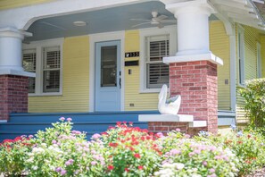 A yellow house with a blue door, a brick chimney, and a white swan statue. - NEW LISTING! The Swan on Park: Historic Charm near Lake Hollingsworth & FSC (Lakeland)