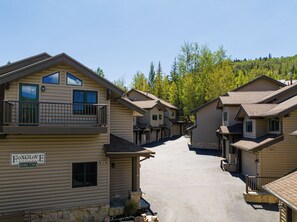 Une rangée de chalets de style rustique, avec une allée centrale, numérotés 710, et une enseigne indiquant « Foxglove Cottages ».