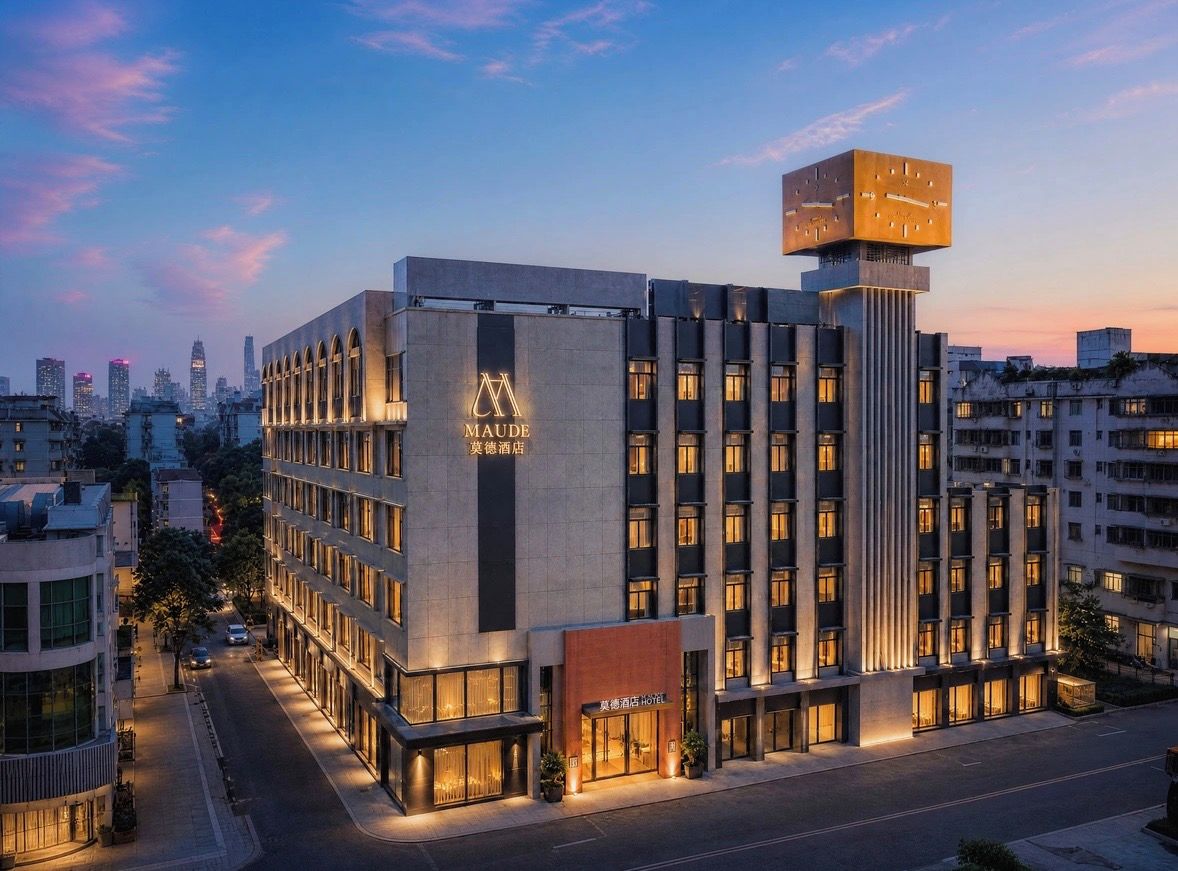 A modern hotel with a prominent sign, multiple floors, and a large clock tower.