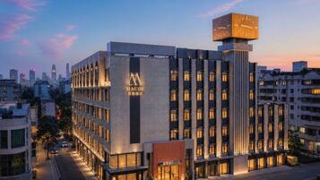 A modern hotel with a prominent sign, multiple floors, and a large clock tower.