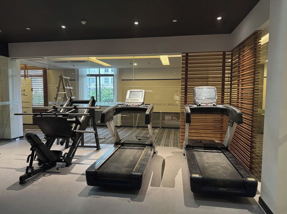 Un gimnasio moderno con cintas de correr, una bicicleta estática y una máquina de remo.