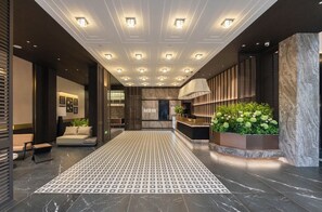 Un lobby moderno con piso estampado, una recepción y un área de estar.