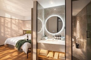 A modern hotel room with a bed, a bathroom with a large mirror, and a shower area. - MAUDE HOTEL NANNING (Nanning)