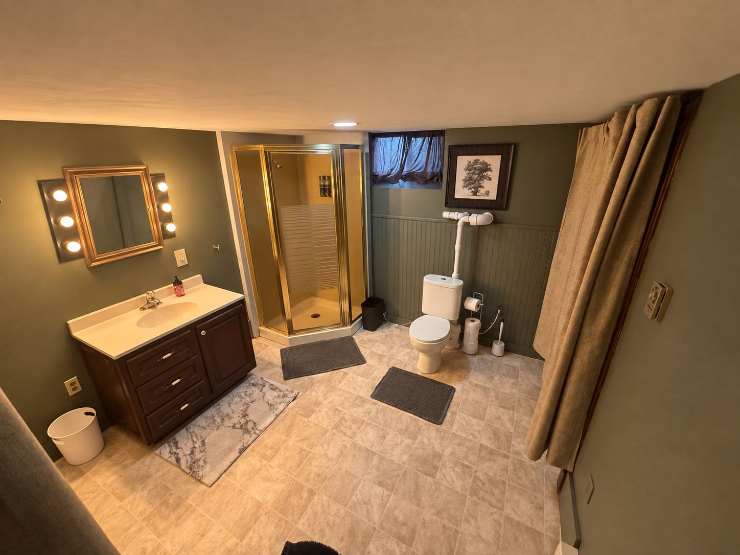A bathroom with a vanity, a shower, and a toilet.