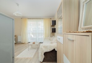 Une chambre à coucher moderne, avec un lit, des tables de chevet, une armoire et une fenêtre avec des rideaux.