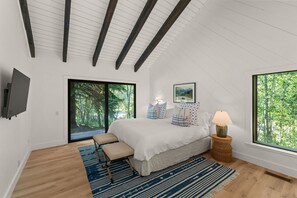 Un dormitorio con una cama, un banco, una lámpara y un cuadro en la pared.