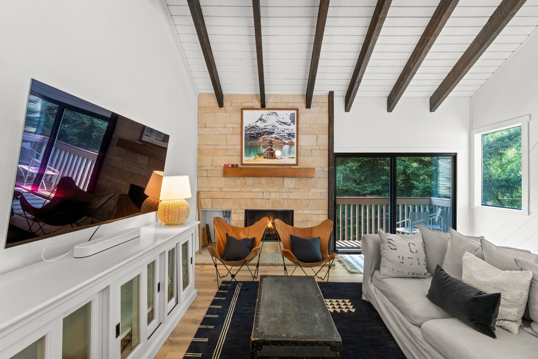 Una sala de estar moderna con chimenea, televisión y sofá.