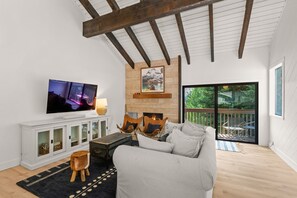 A living room with a fireplace, a television, and a sofa. - Beautiful 3 Bedroom SV Condo with Pool and Hot Tub (Sun Valley)