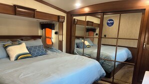 Un dormitorio con dos camas, un armario y un espejo.