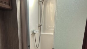 Un baño con ducha, inodoro y lavamanos.