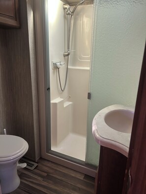 A bathroom with a shower, toilet, and sink. - Spacious, fully stocked RV in quiet, peaceful Lynndyl (Lynndyl)