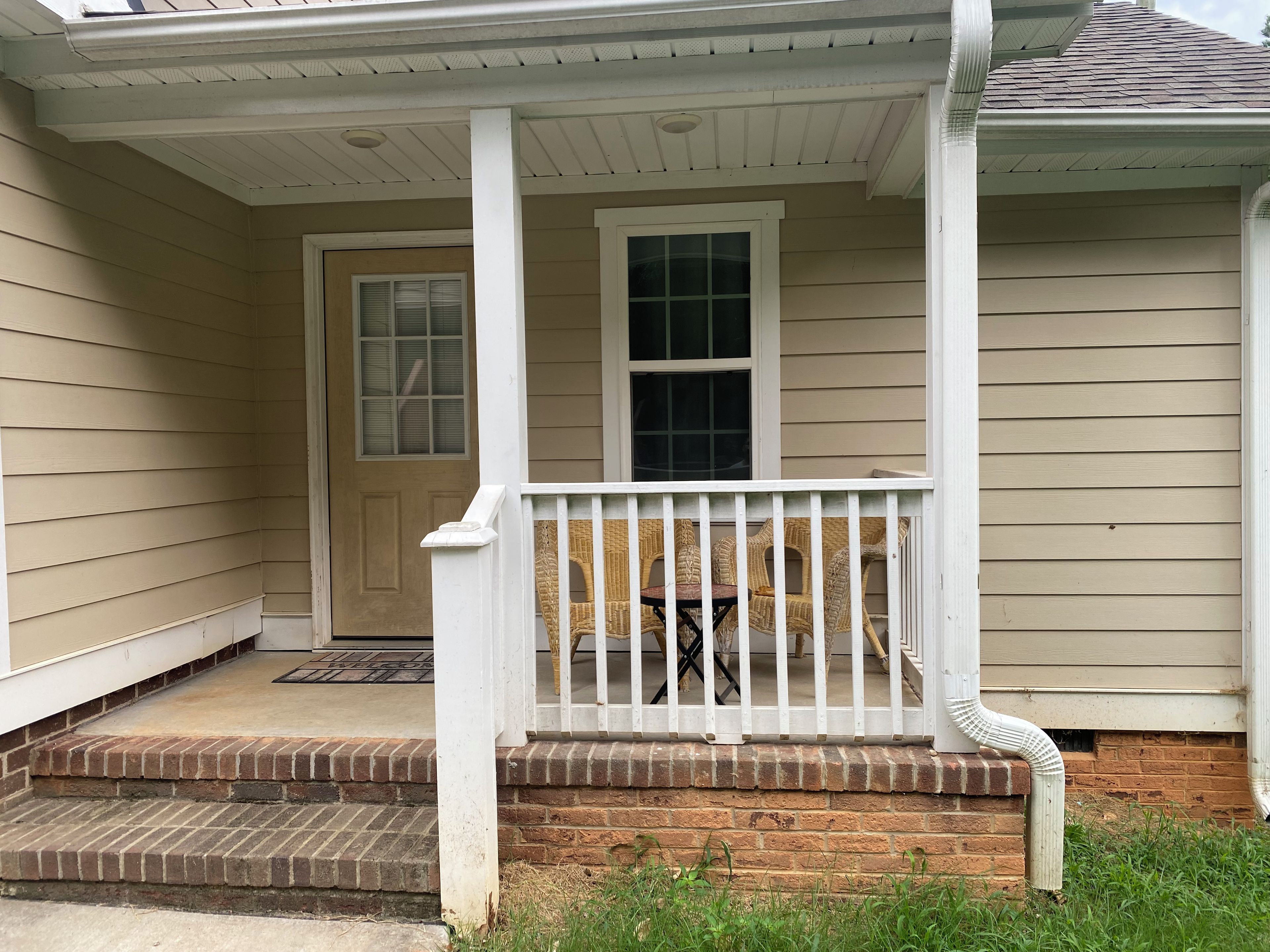 A house with a porch, a door, and a window.
