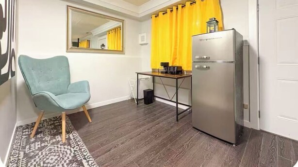 A compact kitchen with a refrigerator, a chair, and a dining table. - 2-bedroom house in Vancouver and close to UBC perfect for relaxing getaways (Vancouver)