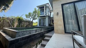 Une maison moderne à deux étages, dotée d’une piscine, d’un patio couvert et offrant une vue sur les environs.