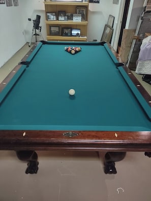 A pool table with balls, a telescope, and a shelf with framed photos. - Bed and Breakfast • King Bed + Game Room + Fire Pit (Kiron)
