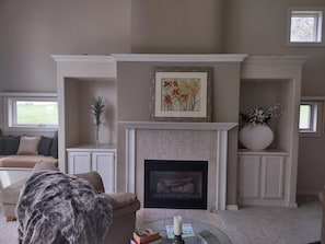 A living room with a fireplace, a sofa, a coffee table, and a large vase.