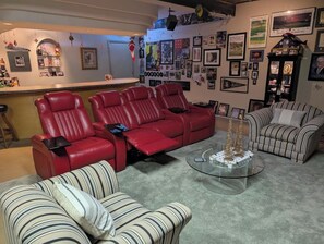 A living room with a red sofa set, a striped sofa, and a glass coffee table.