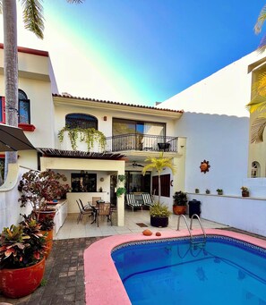 A residential property with a swimming pool, outdoor furniture, and potted plants. - Delightful 3-bedroom house with pool, AC near Marina & Beach in Puerto Vallarta (Puerto Vallarta)